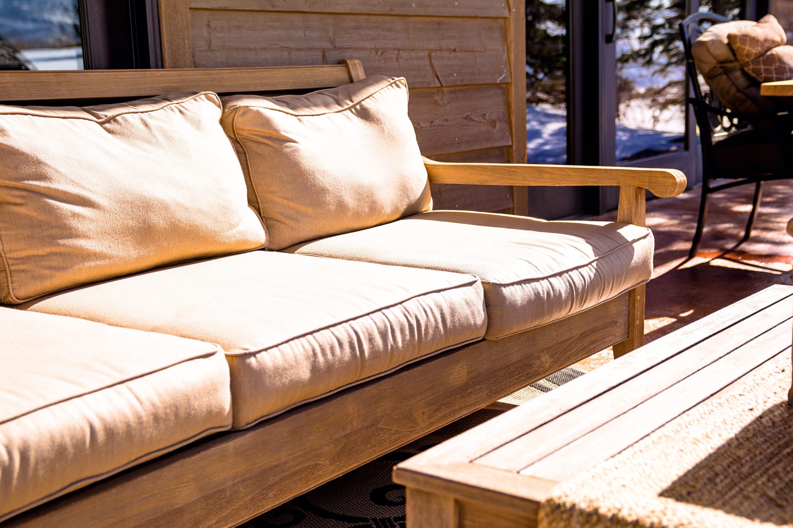 Comfortable outdoor patio seating with cushions, greenery, and a modern relaxed atmosphere